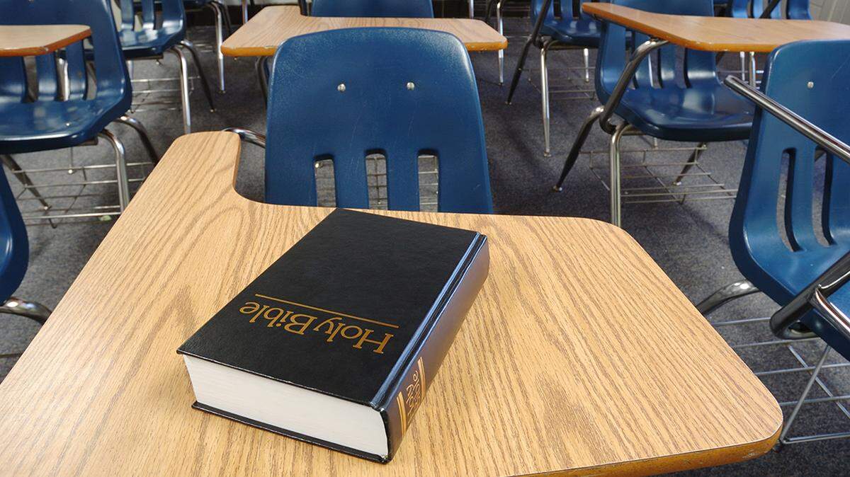 Bible on a school desk in a classroom. religion public education