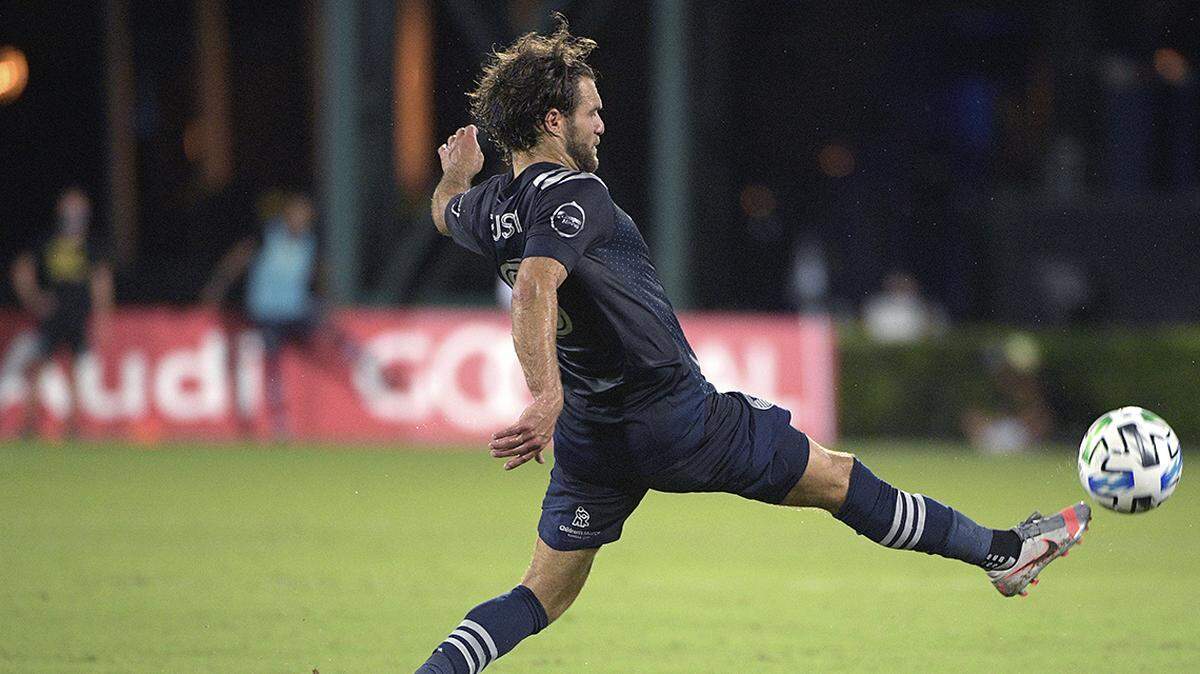 Sporting Kansas City midfielder Graham Zusi reaches for a pass during the first half of an MLS soccer match against the Philadelphia Union, Thursday, July 30, 2020, in Kissimmee, Florida.