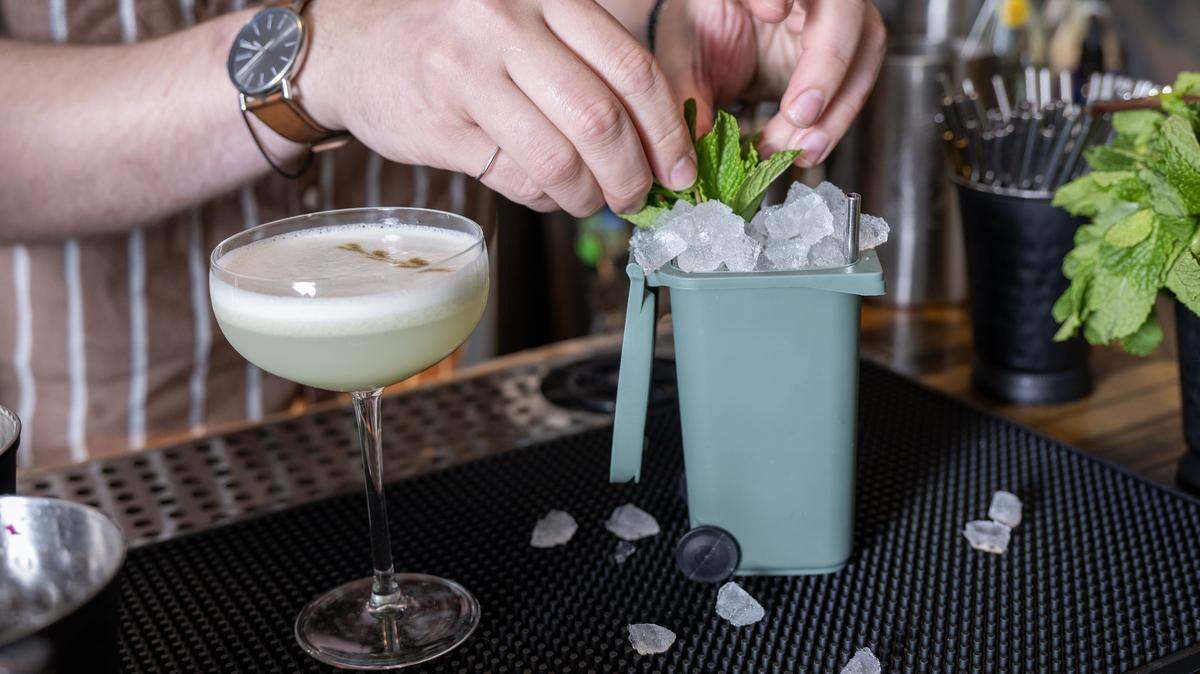 Nate Tallman, left, the bar manager, garnishes a Heavy Bag Night cocktail at Drastic Measures on Thursday, March 12, 2026, in downtown Shawnee bar. Drastic Measures is once again a semifinalist for a James Beard Award in the Outstanding Bar category.