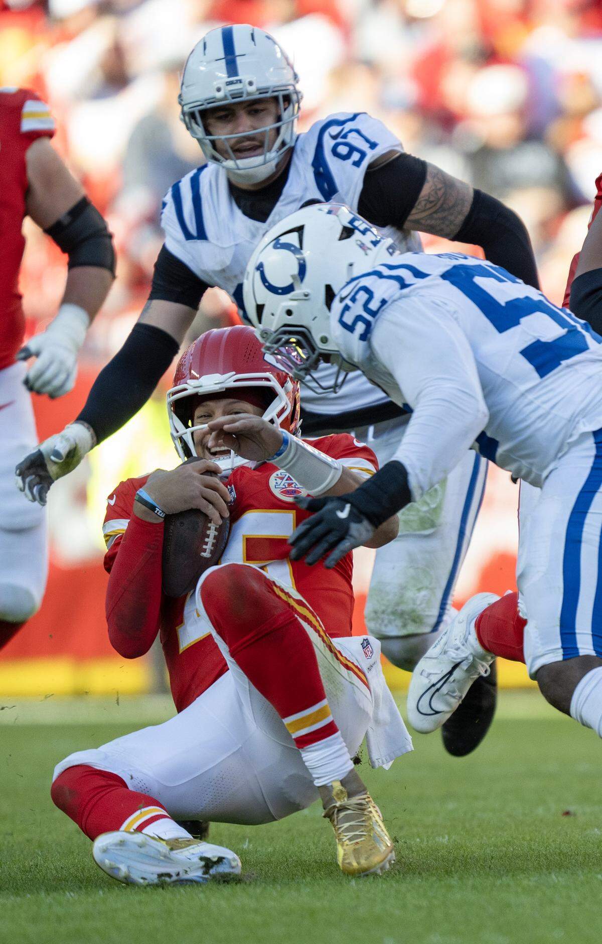 Kansas City Chiefs quarterback Patrick Mahomes (15) slides as he is pressured by Indianapolis Colts defensive end Samson Ebukam (52) and defensive end Laiatu Latu (97) in the second half Sunday, Nov. 23, 2025 at GEHA Field at Arrowhead Stadium in Kansas City. The Chiefs defeated the Colts 23-20 in overtime. 