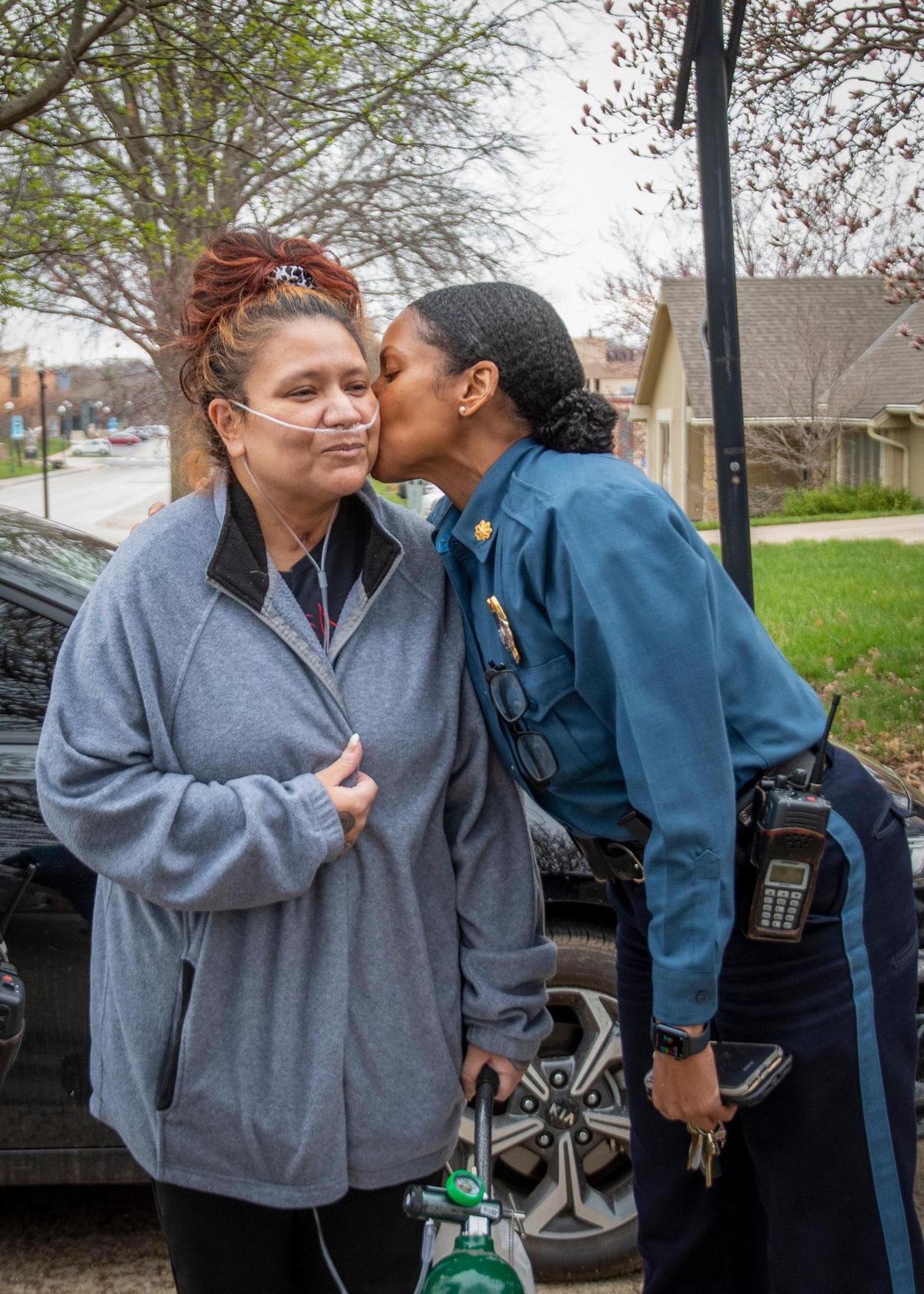 Lisa Sidenstick, a Kansas City police officer, is greeted with a kiss on the cheek by Maj. Kari Thompson, right, during Sidenstick’s homecoming Wednesday. Surviving her grave illness with COVID-19, Sidenstick said, was like having a ‘second chance at life.’