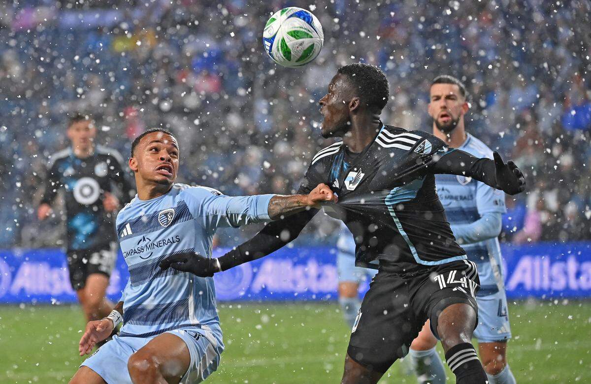 Sporting Kansas City defender Logan Ndenbe (18) and Minnesota United forward Tani Oluwaseyi (14) battle for the ball in the first half at Children’s Mercy Park on March 15, 2025.