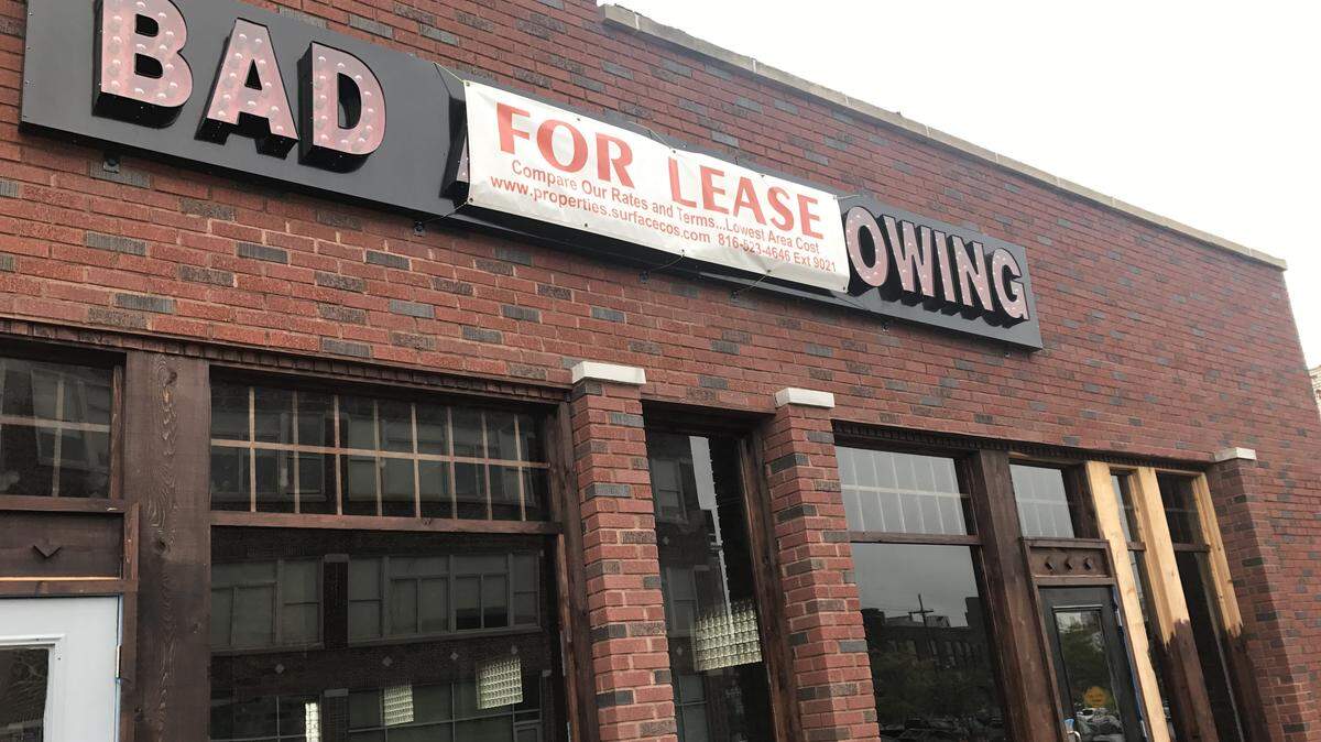 A “for lease” sign covers the Bad Axe Throwing logo, leaving just “bad ... owing.”