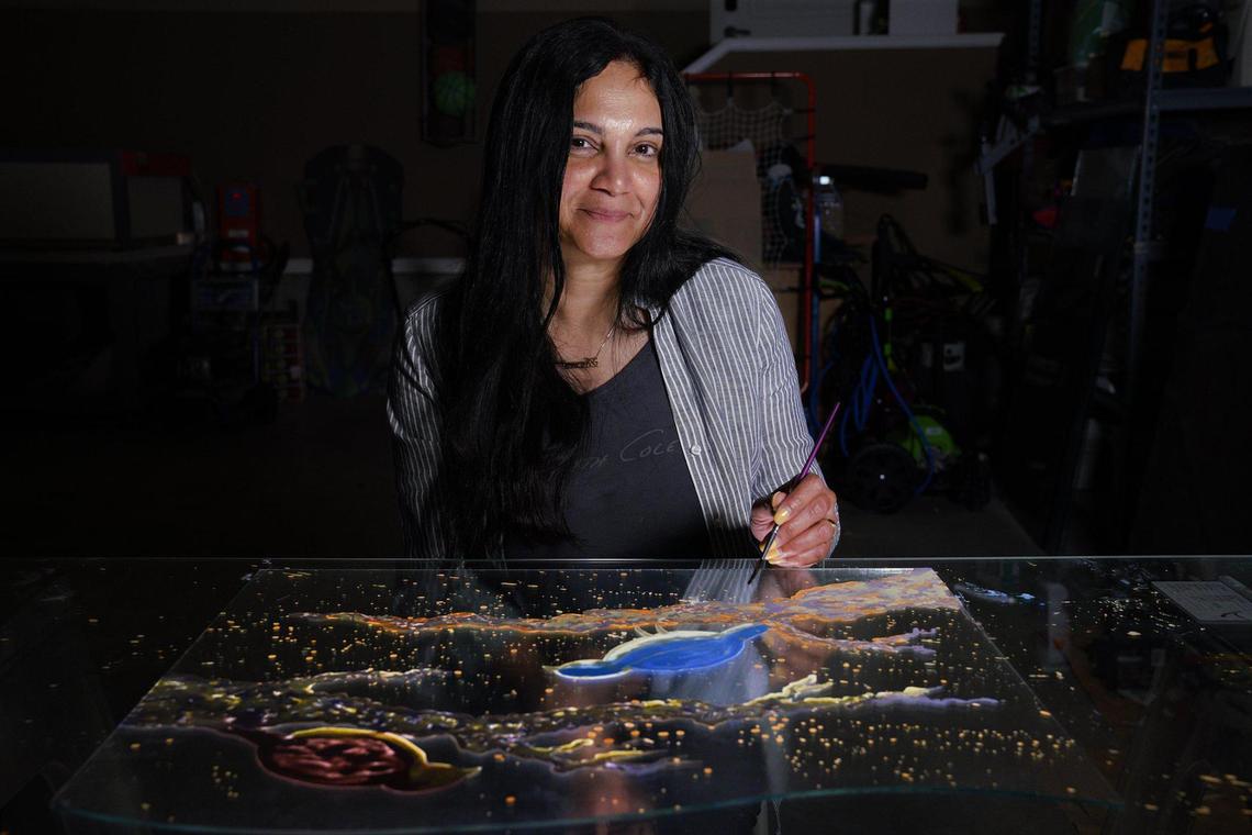 The work Hasna Sal is creating for Kansas City International Airport’s new terminal will comprise 10 panels of painted glass art titled “Nostalgia.” Sal worked on a part of one panel that shows the Kansas state bird, the western meadowlark, and the Missouri state bird, the Eastern bluebird, in her Overland Park home studio recently.
