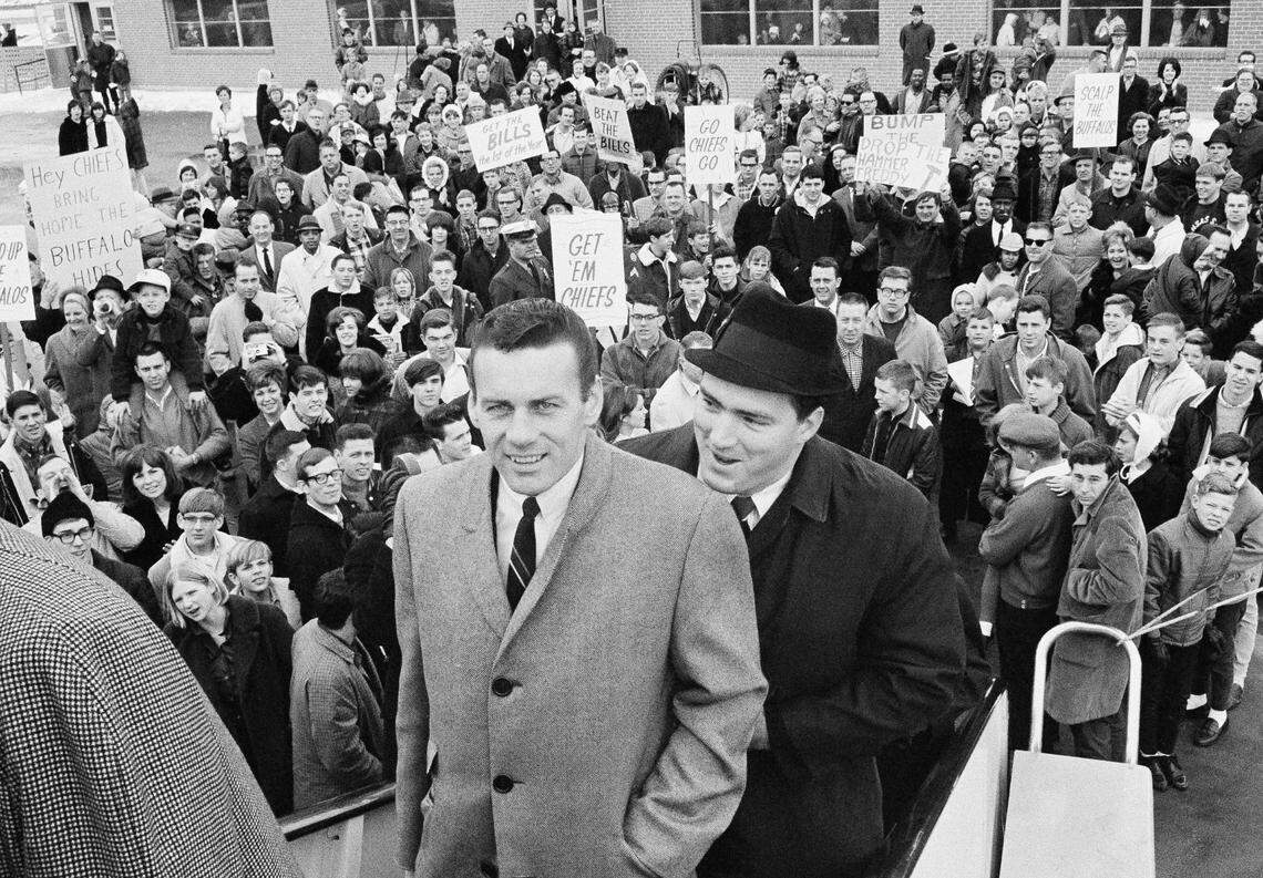Len Dawson (left) and Fred Arbanas board the plane that took the Kansas City Chiefs, AFL Western division champs, to Buffalo, N.Y. where they played the Eastern champs in the New Year’s Day title game. In background, part of the send-off crowd is shown in Kansas City, Dec. 31, 1966.