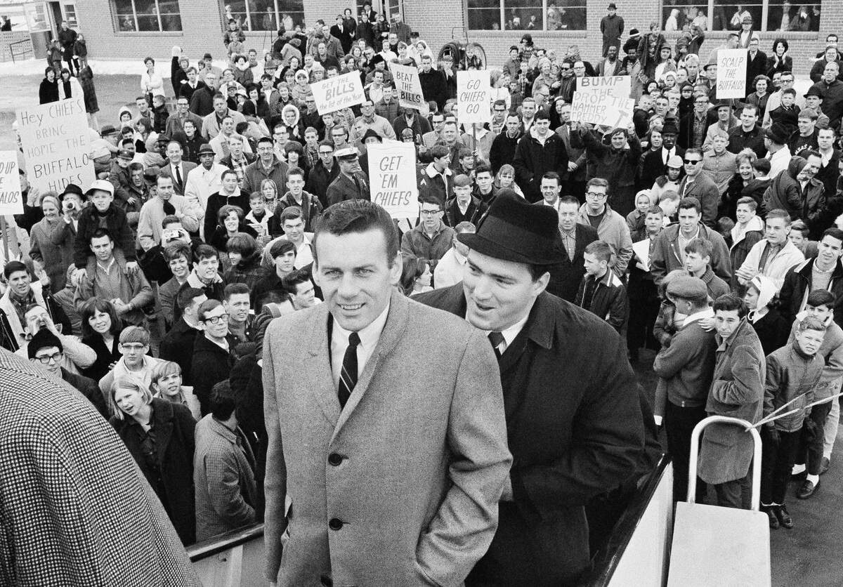 Len Dawson (left) and Fred Arbanas board the plane that took the Kansas City Chiefs, AFL Western division champs, to Buffalo, N.Y. where they played the Eastern champs in the New Year’s Day title game. In background, part of the send-off crowd is shown in Kansas City, Dec. 31, 1966.