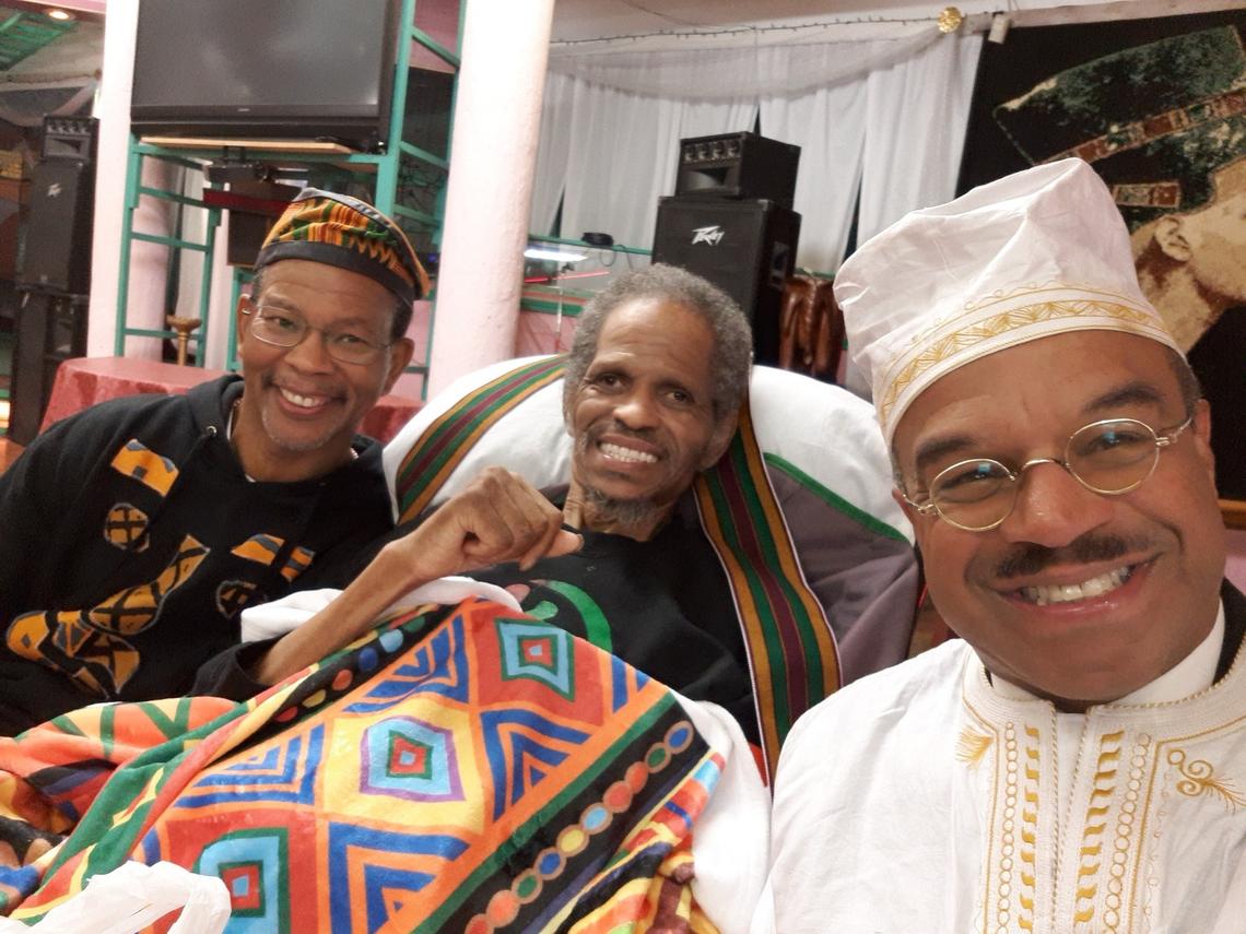 Alvin Sykes, center, is surrounded by Ajamu Wbster and Kansas Sen. David Haley during Kwanza 2019.