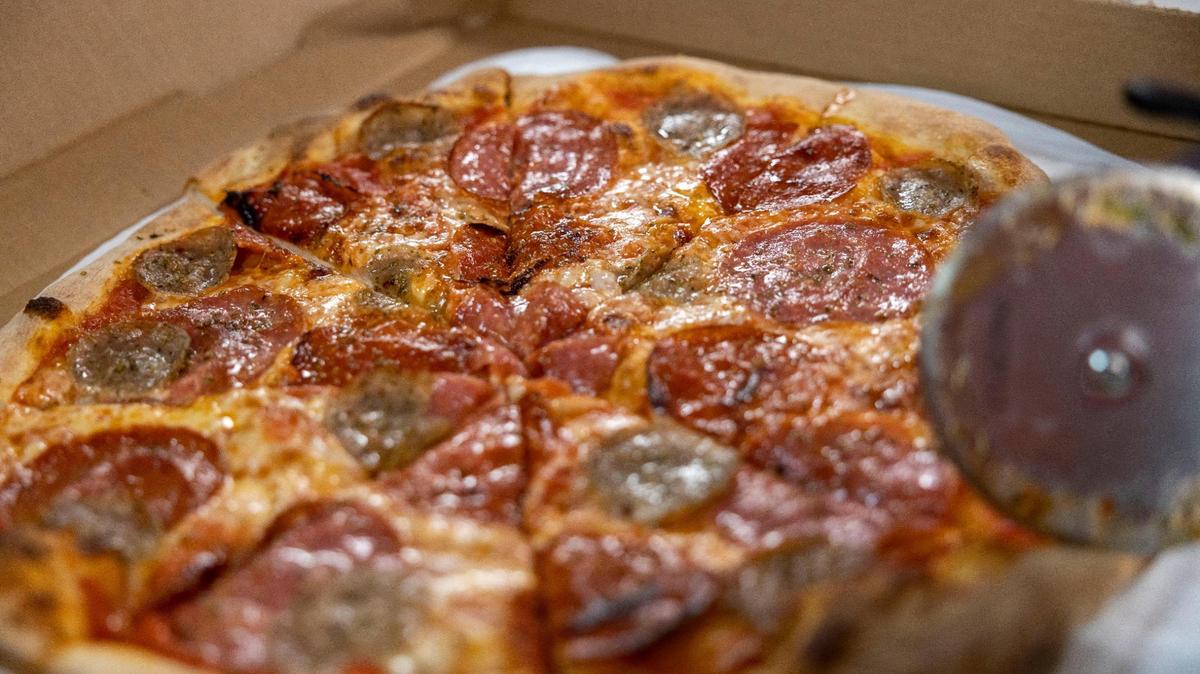 A freshly baked sausage pepperoni pizza, cut into eight slices at the Pizza Tascio in North Kansas City.
