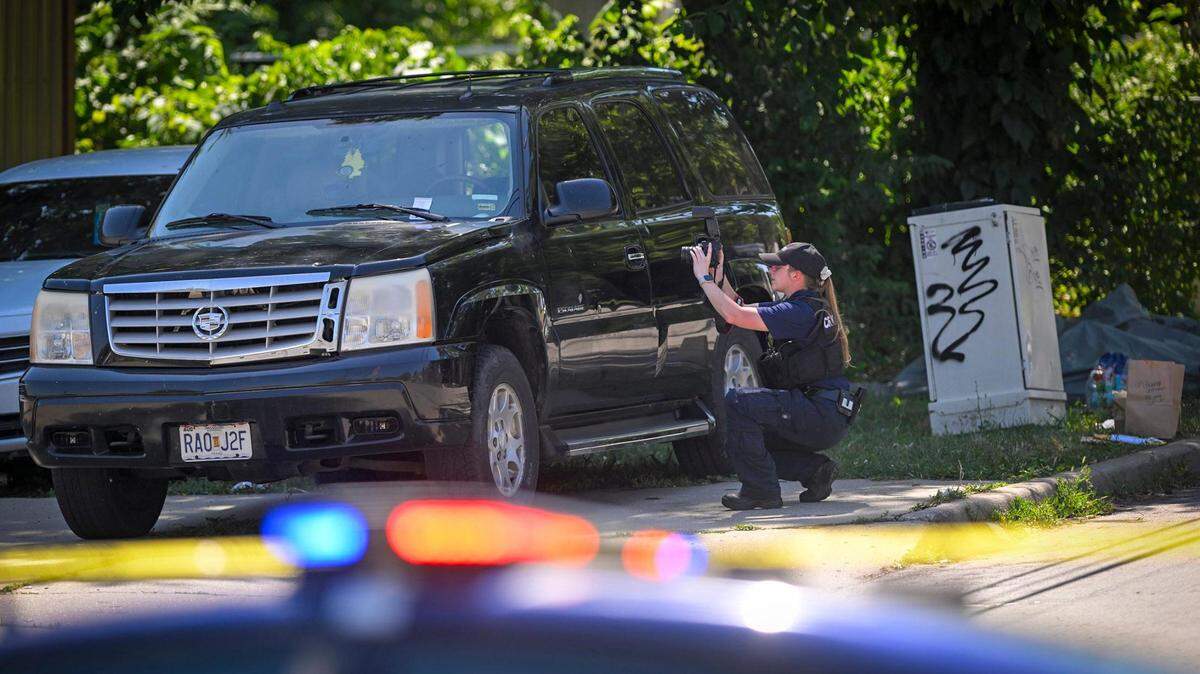 A crime scene investigator took photos near the scene of a shooting where three people died and six were injured early Sunday, June 25, 2023, near 57th Street and Prospect Avenue in Kansas City.