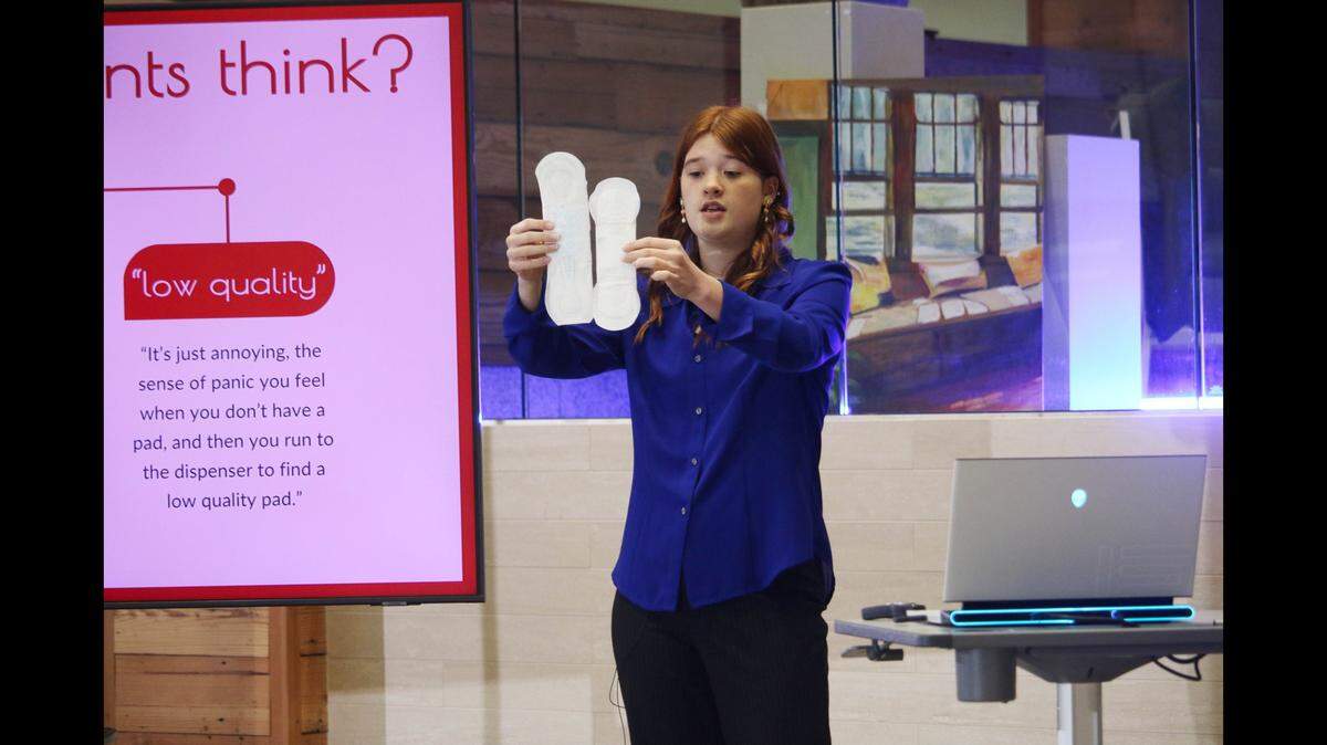 Audrey Jennings, a sophomore at Shawnee Mission West, demonstrates the difference in free sanitary pads currently available in schools and average ones you might buy in a store during The Next Great Pitch Competition. Her project, “The Dot Spot,” will both increase and expand what’s available to students.