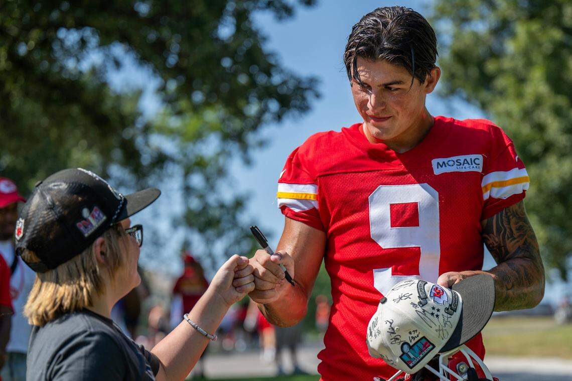 Kansas City Chiefs running back Louis Rees-Zammit gives a fist pump to a young fan while signing autographs after a practice at Chiefs training camp. Rees-Zammit was a professional rugby player in England and is now working to get a spot with the Chiefs playing American football.