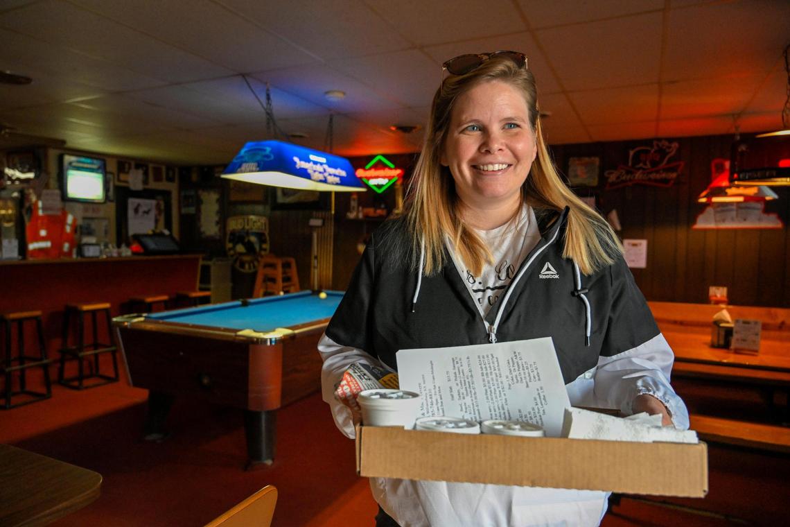 Elizabeth Tice of Osage City, Kansas, heads out the door with her order, a slab or ribs and some sides. To-go orders at Guy and Mae’s are boxed up in beer flats.