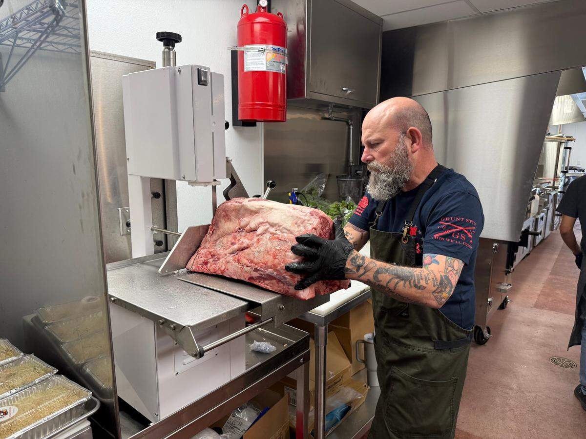 Michael Harrell, one of the owners of Bellator Holdings, slices beef on Friday morning ahead of his shop’s opening.