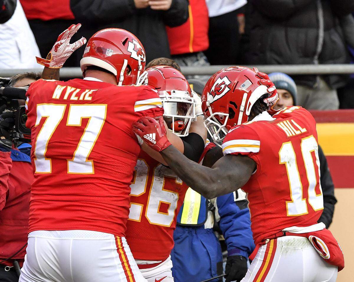Kansas City Chiefs guard Andrew Wylie (77) and wide receiver Tyreek Hill (10) celebrate with running back Damien Williams after Wiliams scored on a catch from quarterback Patrick Mahomes late in the fourth quarter against the Baltimore Ravens in Kansas City. It was Mahomes’ 45th touchdown pass of the 2018 regular season.