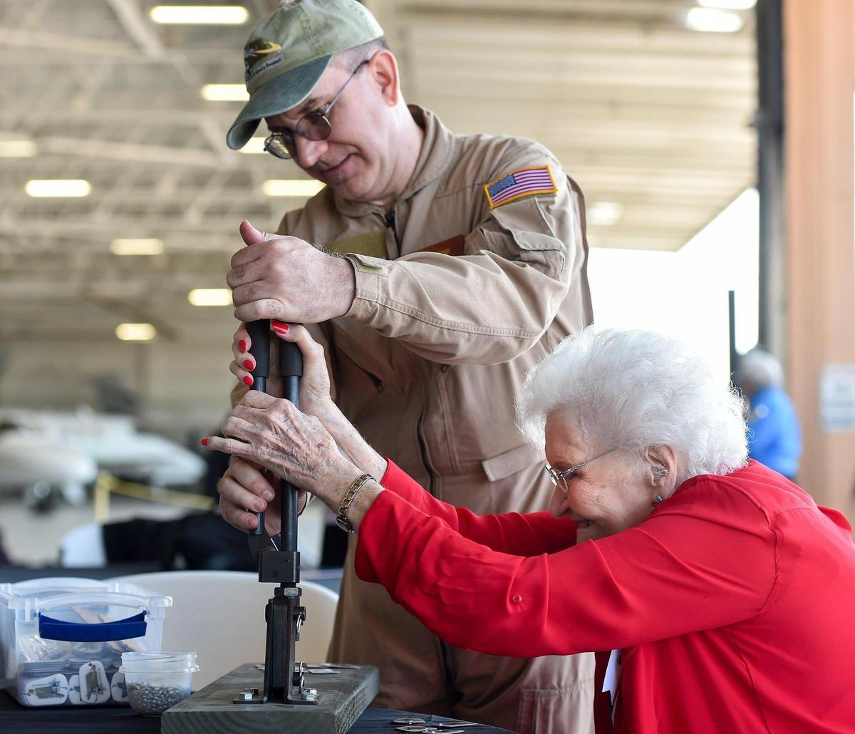 Emma Newland of Lee’s Summit drives rivets in a dog tag with the help of Dan desko, president and CEO of the B-25 History Project. Rosie’s Reply, a B-25D bomber built at the North American Aviation plant in Fairfax, arrived at Charles B. Wheeler Downtown Airport Monday, Oct. 4, 2021, the first time it has been back to Kansas City since it flew out for World War II. Newland was a Rosie who helped build the bomber at Fairfax.