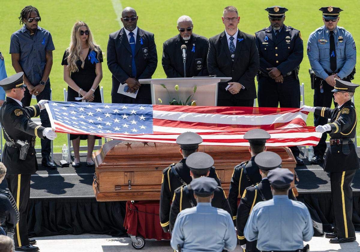 Members of an honor detail lift the U.S. flag from Officer Hunter Simoncic's casket during a memorial service at ChildrenÕs Mercy Park on Wednesday, Sept. 3, 2025, in Kansas City, Kansas. Simoncic was killed Aug. 26 after being struck by a fleeing driver while deploying stop sticks.