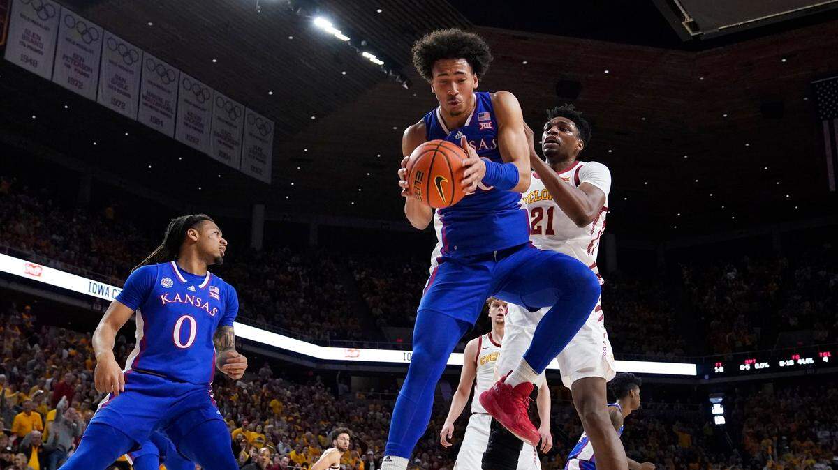 Kansas forward Jalen Wilson grabs a rebound in front of Iowa State center Osun Osunniyi during the first half of a game, Saturday, Feb. 4, 2023, in Ames, Iowa.