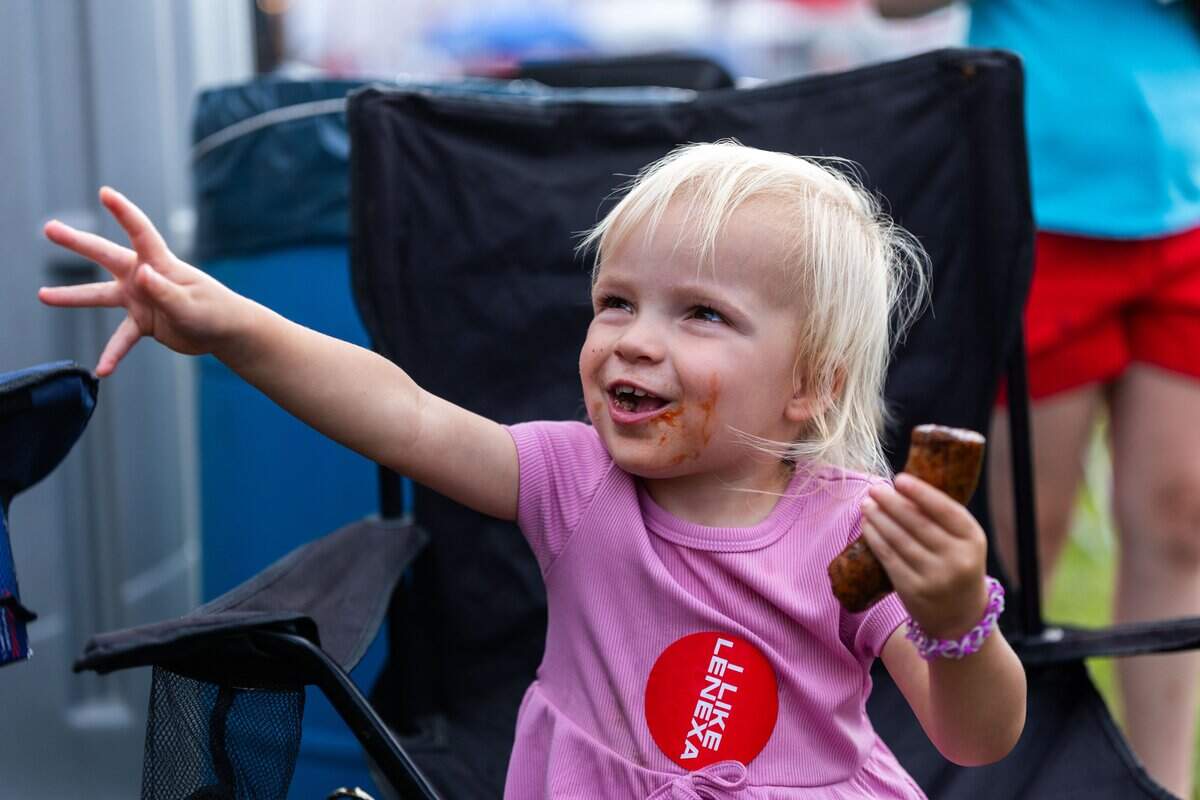 Dottie Mawhiney, two, enjoys a sausage at The Great Lenexa BBQ Battle on Friday, June 26, 2026.