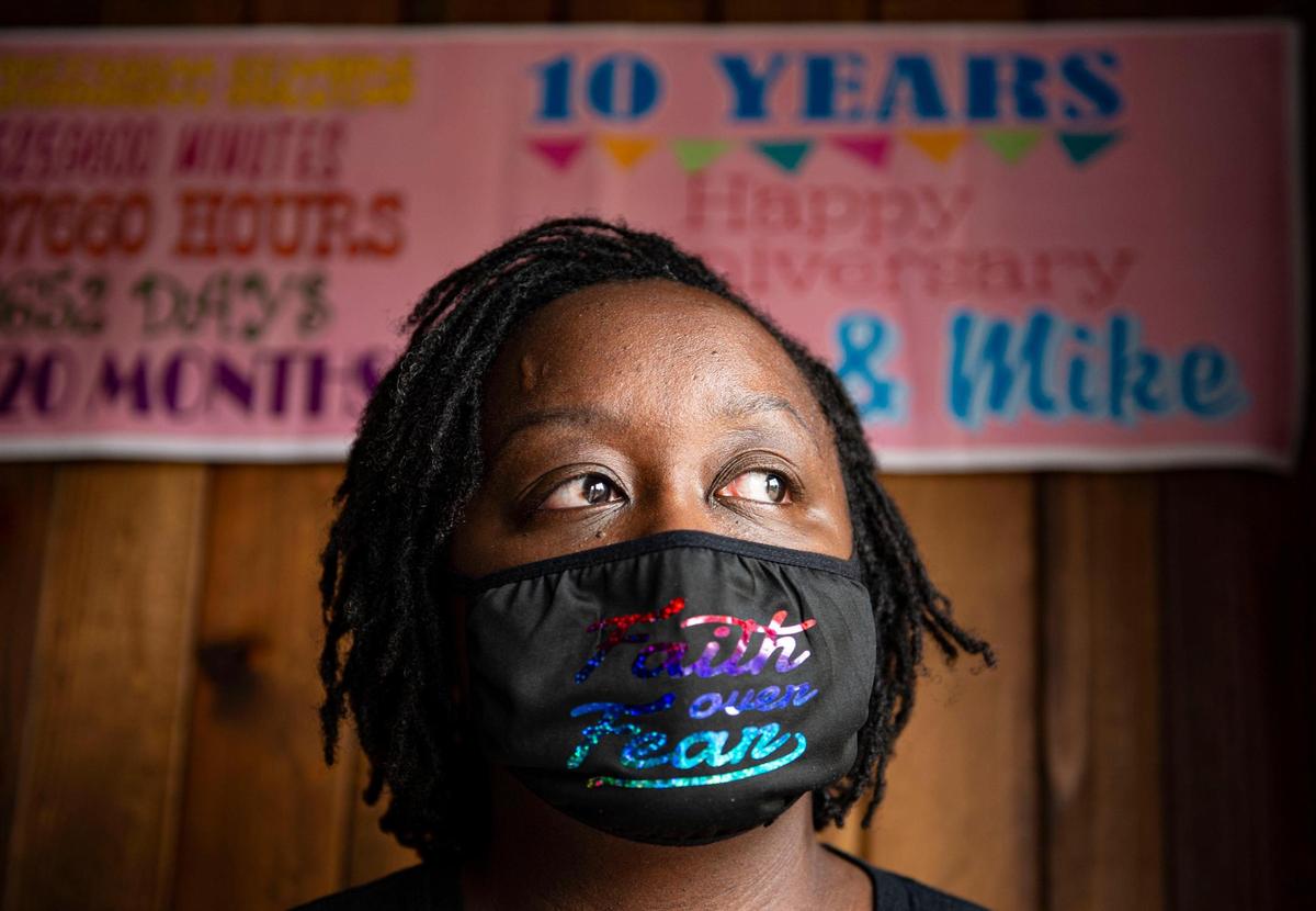 Venus Griswold, wife of Michael Griswold, stands at the family home, Thursday, June 17, 2021, in Kansas City, Mo. The sign behind her hangs in her dining room celebrating their 10th year anniversary they spent together while he was in the hospital in March due to effects from COVID-19 before passing in May. “We all go through things and it’s all for a purpose and I’m just trying to understand what this particular purpose is” Griswold said.