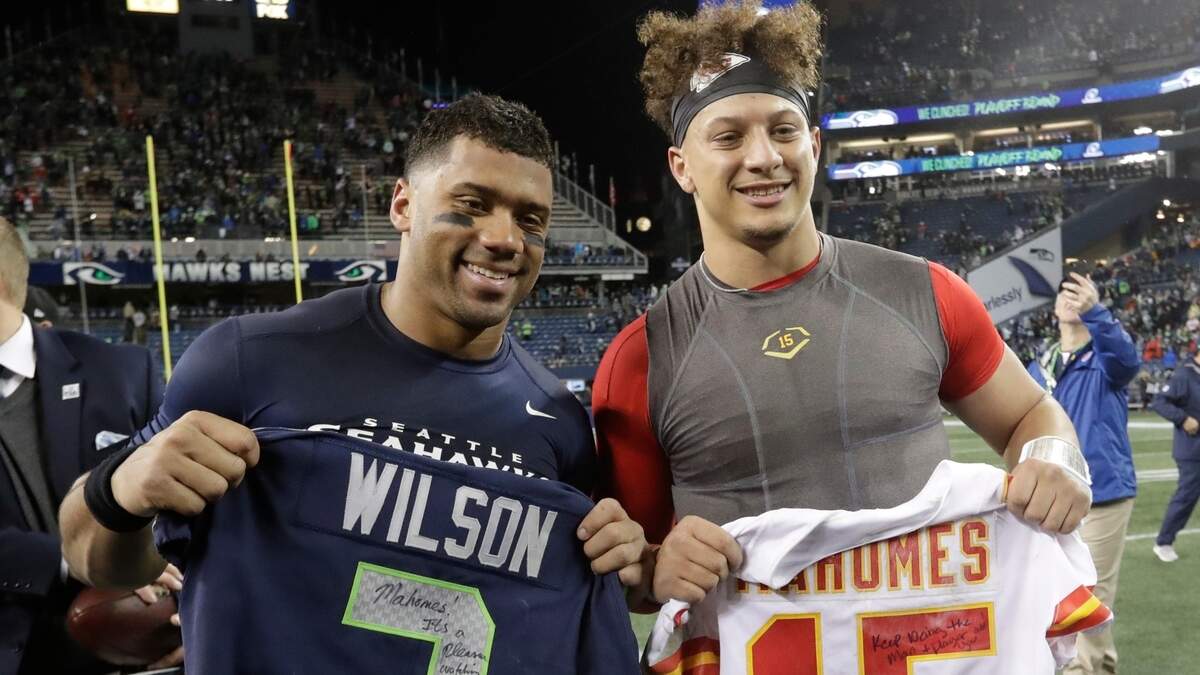 Seattle Seahawks quarterback Russell Wilson, left, and Kansas City Chiefs quarterback Patrick Mahomes, right, pose for a photo after they swapped jerseys after an NFL football game, Sunday, Dec. 23, 2018, in Seattle. The Seahawks won 38-31.(AP Photo/Elaine Thompson)