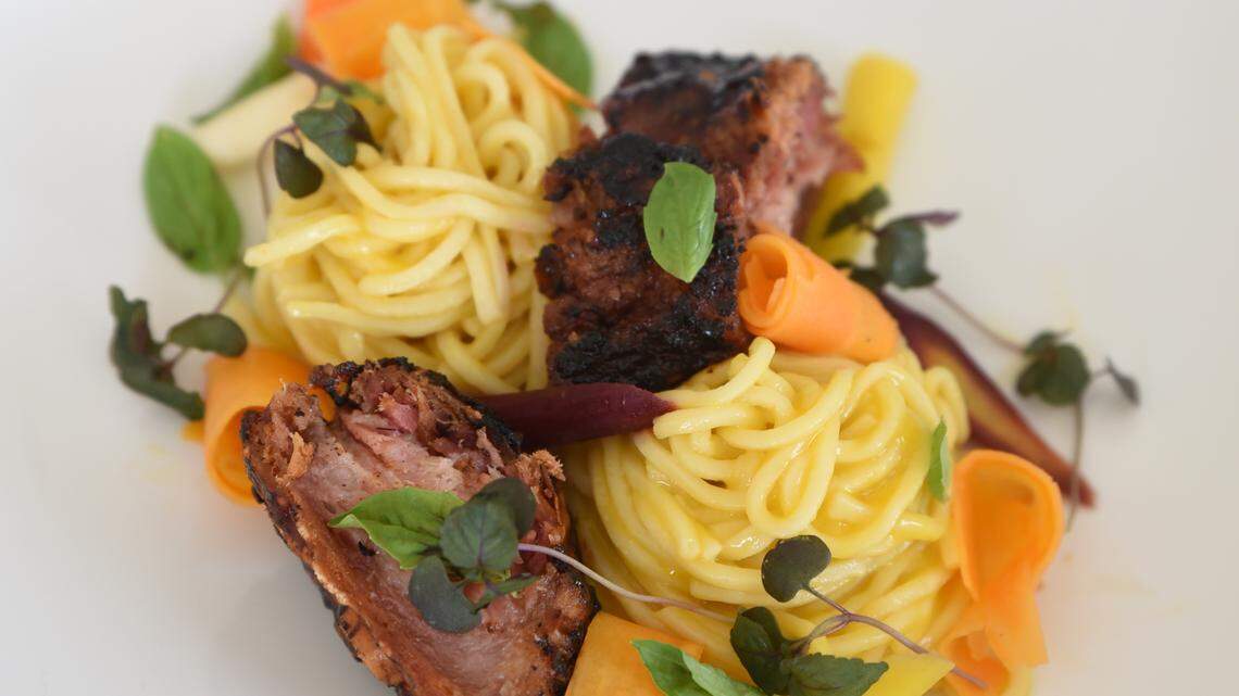 The Dining Experience at the Kauffman Center includes Circle B Ranch Brown Sugar Pork Belly served with soba noodles, pickled green mango vinaigrette, a sweet potato ribbon, and heirloom carrots