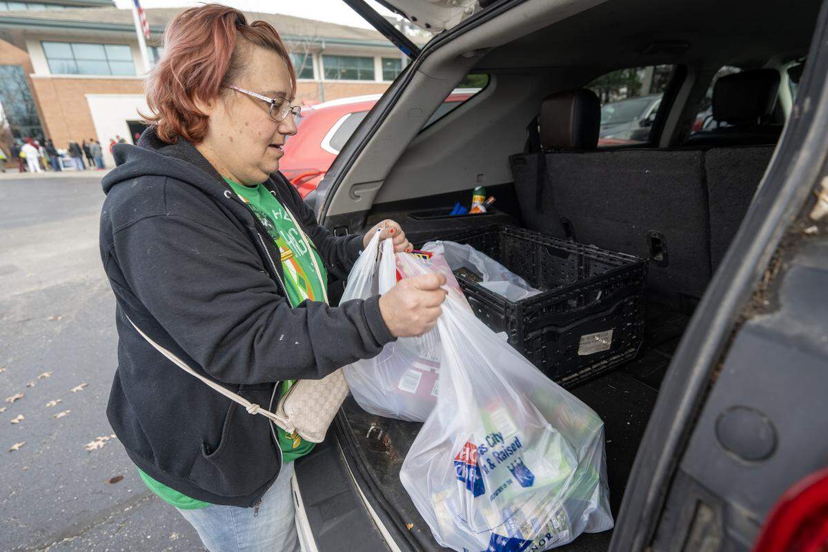 Amanda Jefferson, of South Kansas City, loads bags of groceries into her car during Harvester’s monthly food distribution event at Jackson County Public Health in Lee’s on Wednesday, November 19, 2025. The event, which attracted a large turnout, is part of ongoing efforts to combat food insecurity in the community by supplying residents with essential food items.