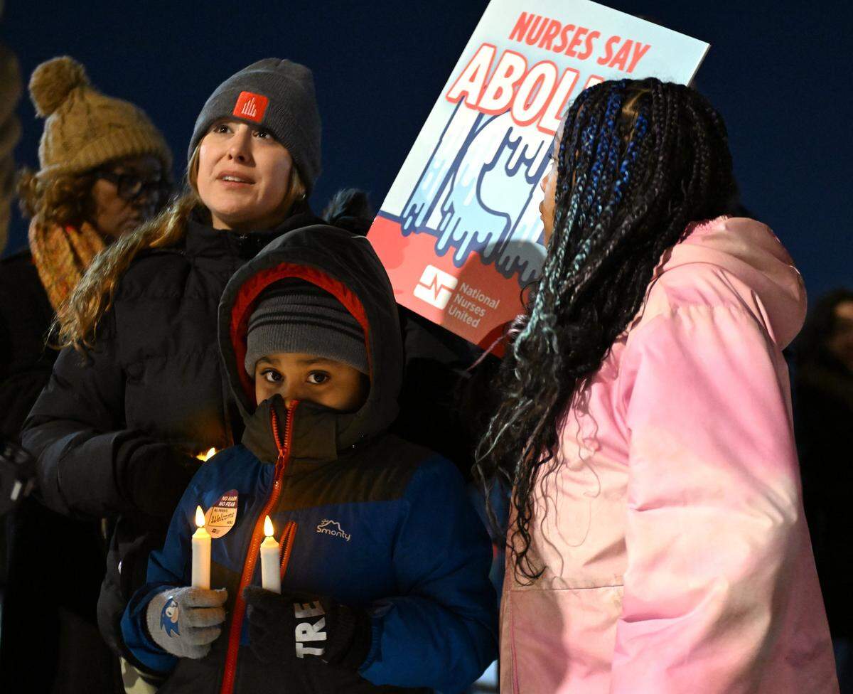 Jessica Acosta, left, and her children seven-year-old Tre Acosta and 10-year-old Nica Acosta attend a candlelight vigil outside Research Medical Center to honor Alex Pretti on Thursday, Jan. 29, 2026, in Kansas City.