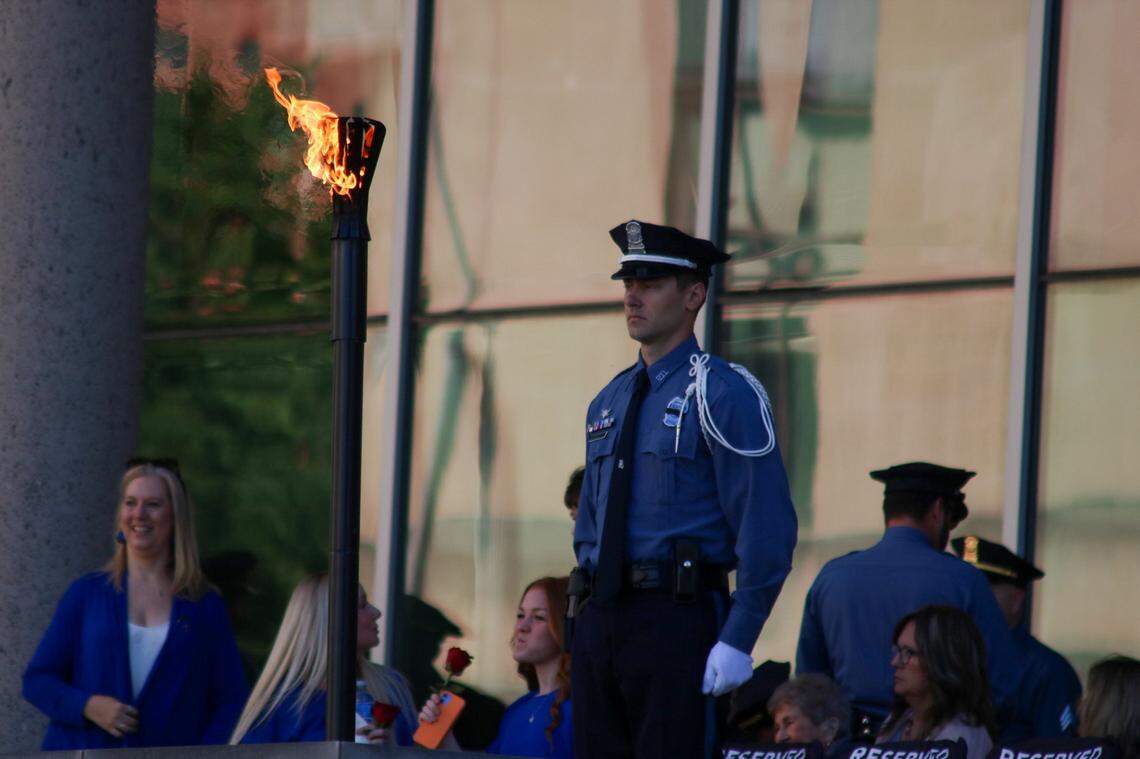A Kansas City police officer stands near a flame during an annual ceremony May 9, 2024 that honored 120 fallen officers dating back to 1881.