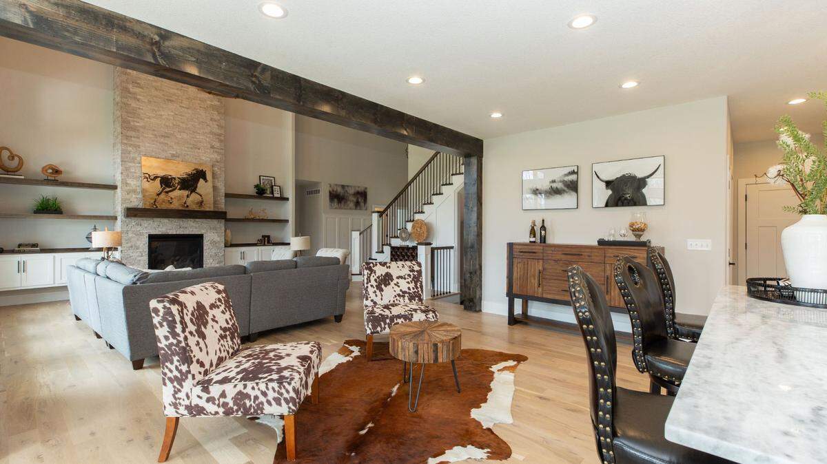 A large two-story great room in this Lee’s Summit home features a floor-to-ceiling stone fireplace.