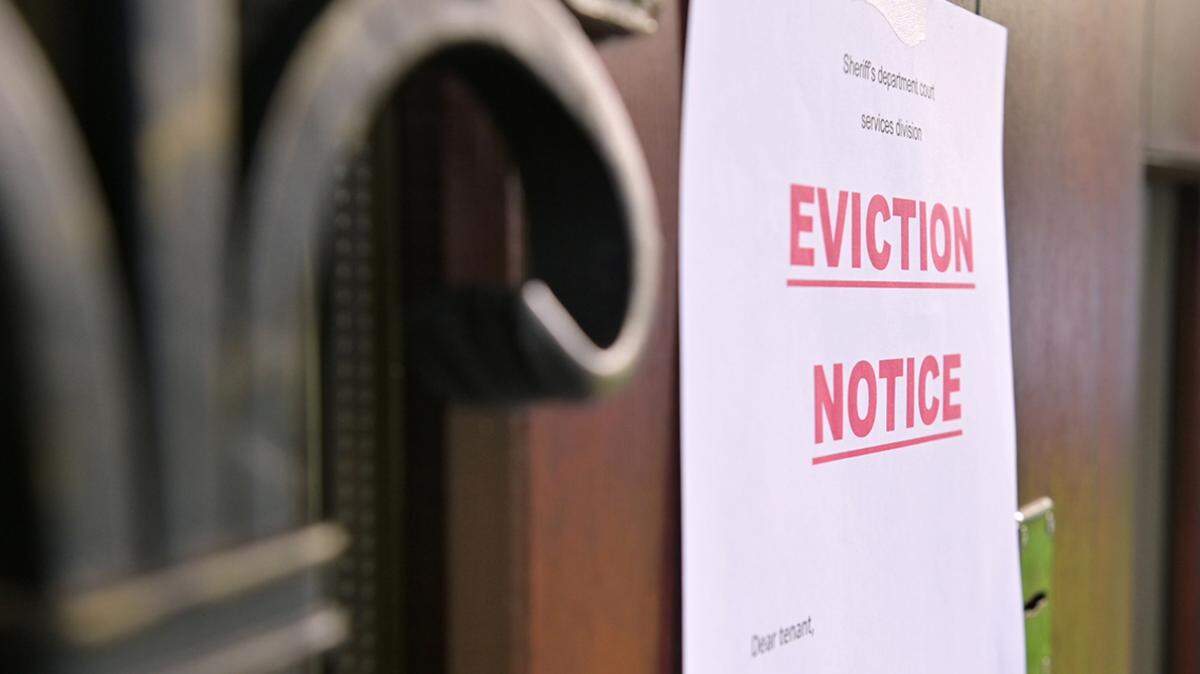 the notice of eviction of tenants hangs on the door of the house, front view rent renter landlord tenant