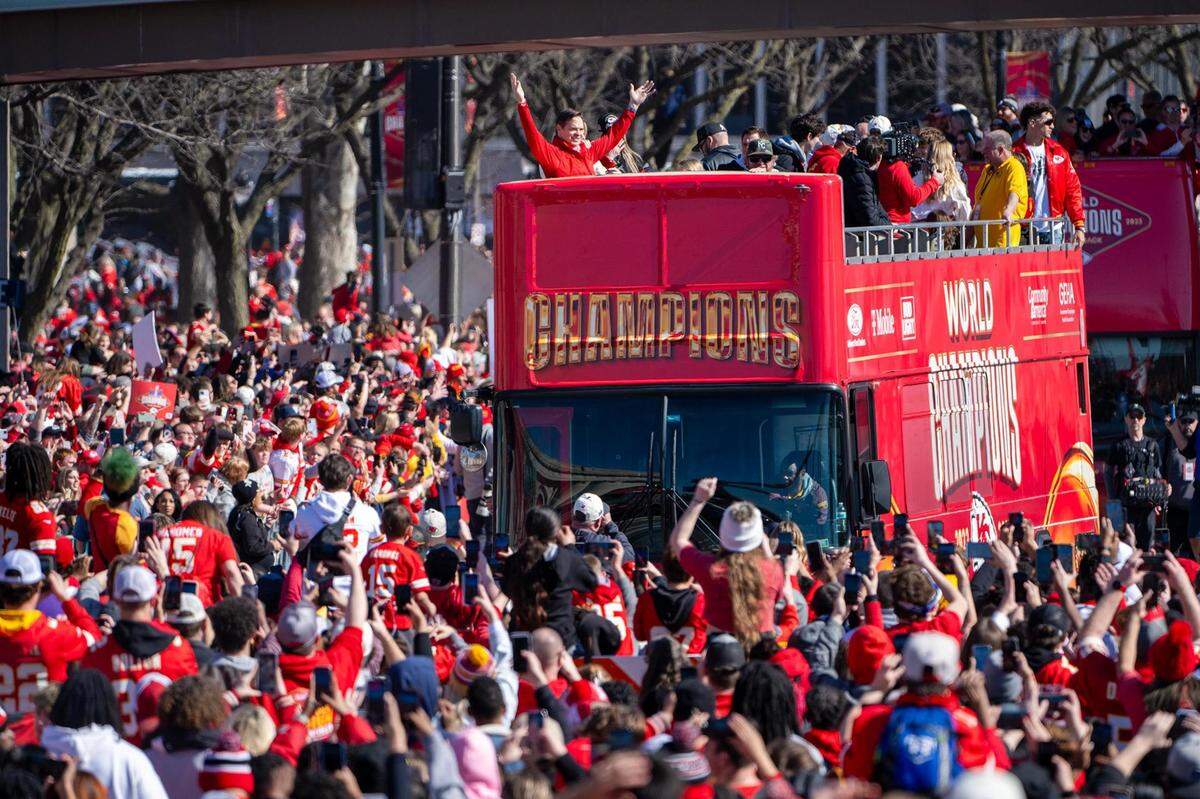 Mark Donovan, president of the Kansas City Chiefs, raises his arms as the bus makes the turn toward Union Station during the Chiefs Super Bowl LVIII parade on Feb. 14, 2024.