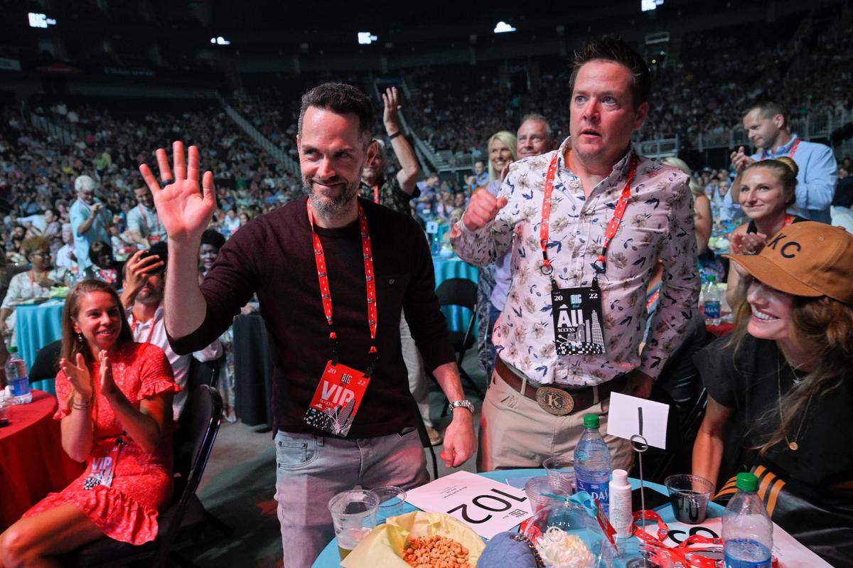 The Big Slick crowd applauded after Scott Gorran, left, of Indiana placed the winning $50,000 bid to appear on stage at next spring’s NFL Draft in Kansas City. He and his wife, Ann Brady, far right, also bid $100,000 to fly to London and play extras on “Ted Lasso.”