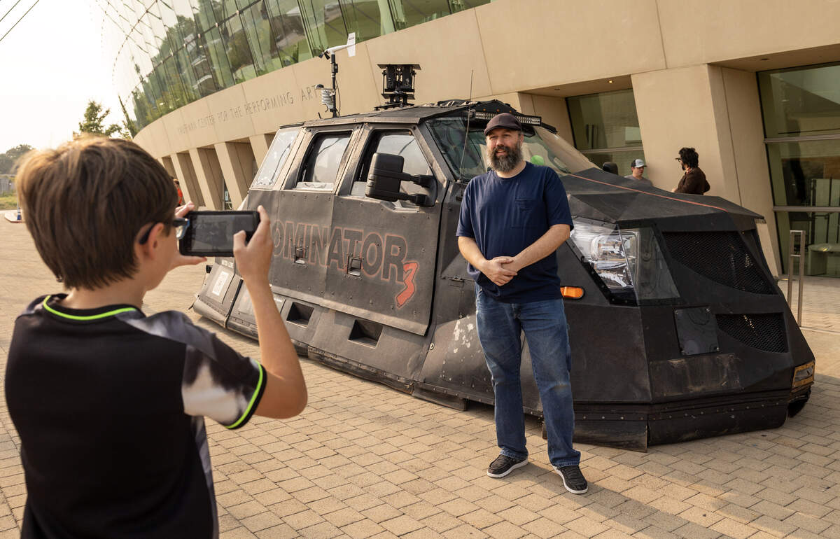 Nick McLaughlin, of Independence, poses for a photo taken by his son Tristan, with the Dominator 3 outside the Kauffman Center for the Performing Arts on Thursday.