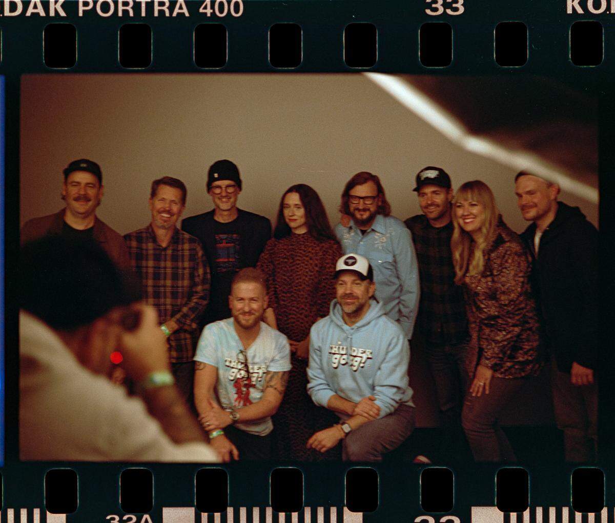 Jason Sudeikis posing alongside the Thundergong team