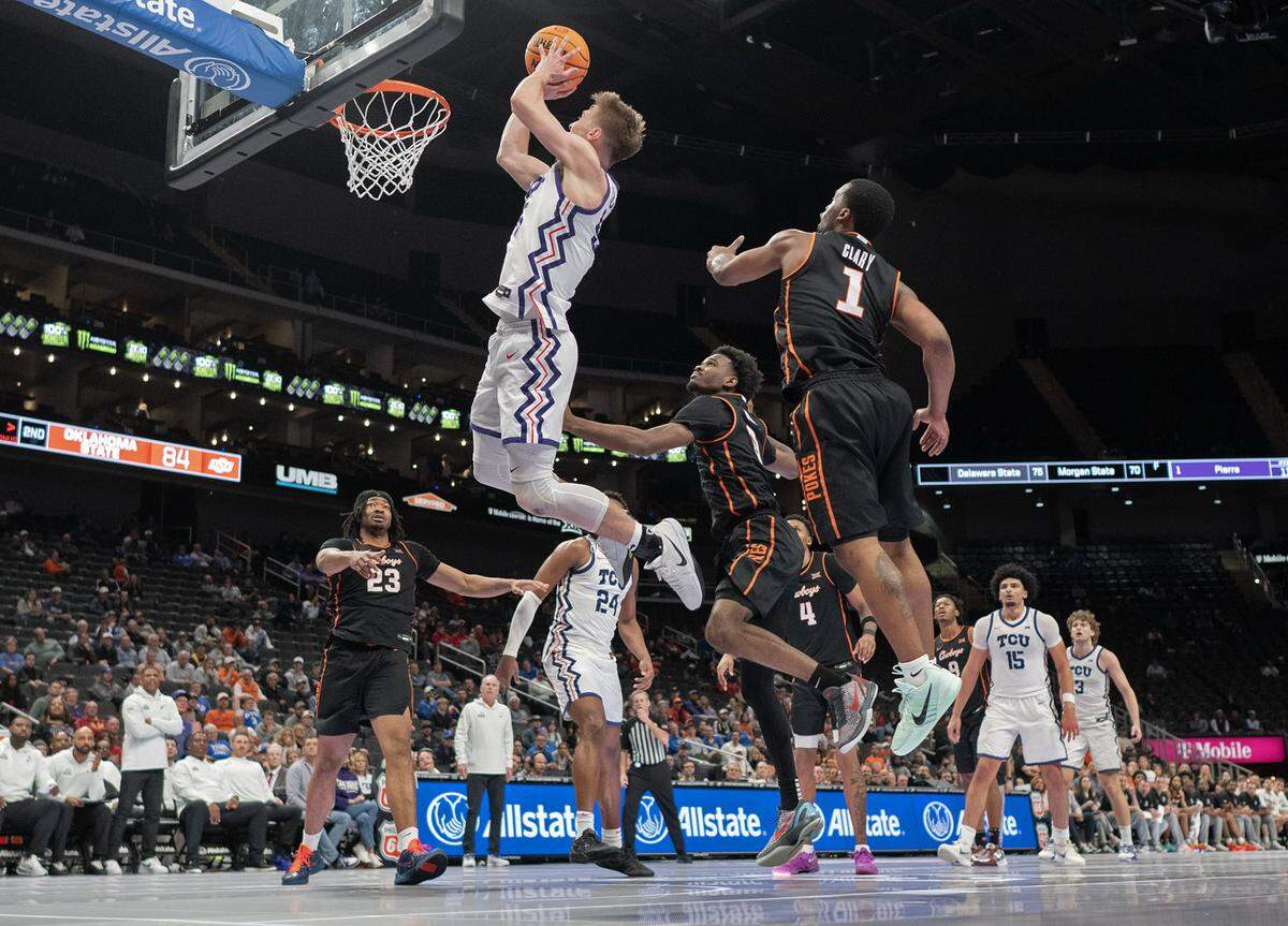 Texas Christian University Horned Frogs guard Tanner Toolson (55) shoots as Texas Christian University Horned Frogs guard Jayden Pierre (1) defends during the second half of the Big 12 Men's Basketball Tournament at T-Mobile Center on Wednesday, March 11, 2026, in Kansas City. TCU defeated OSU, 95-88.