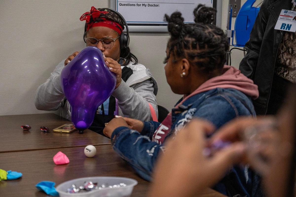 Skylah Canady, 15, demonstrates her understanding of pregnancy contractions by squeezing a balloon containing a ping pong ball inside