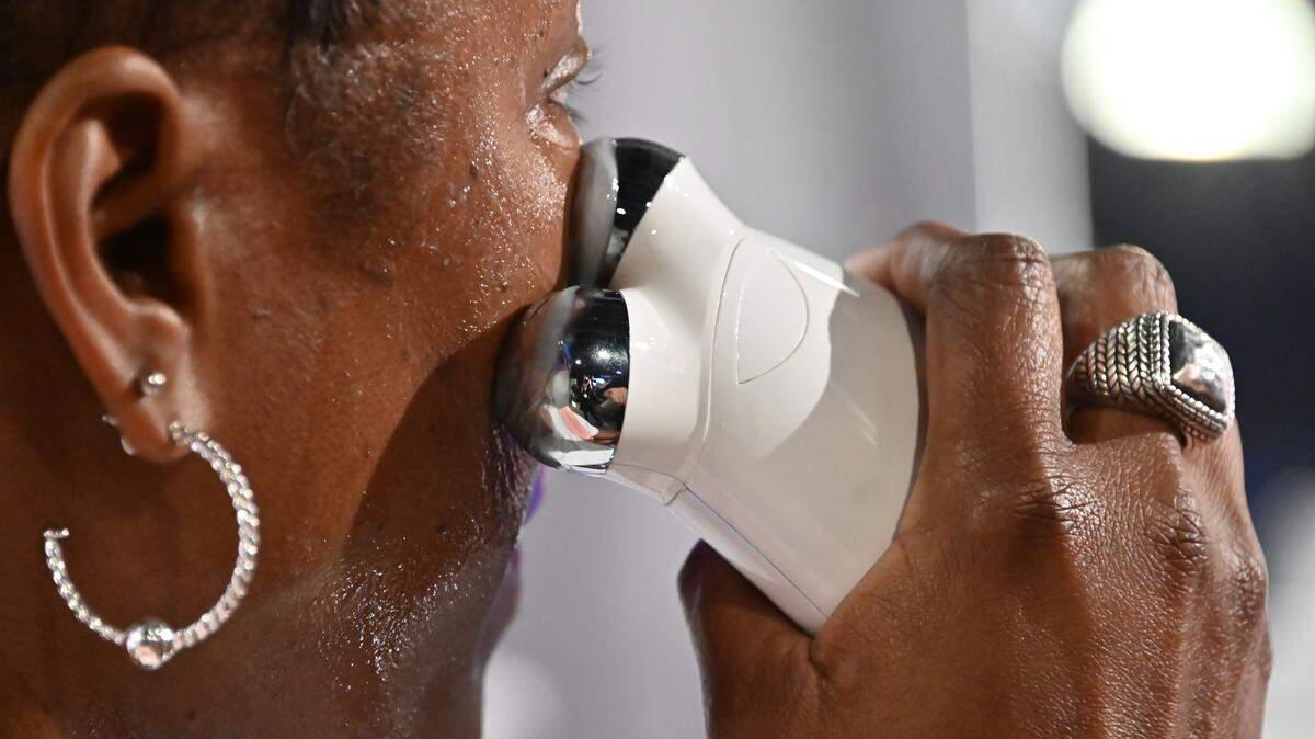 A woman using a facial tool.