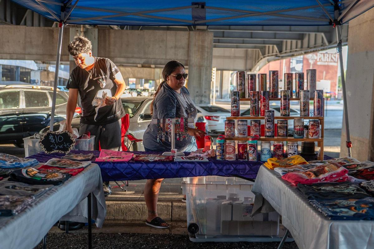 Michelle Elizondo, owner of Michelle’s Creations, organizes merchandise at her booth during the First Fridays Under the Bridge.