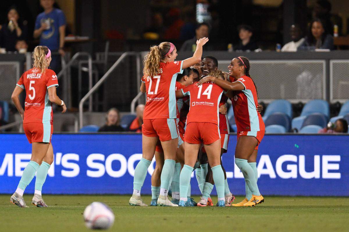 Teammates converge around Kansas City Current forward Temwa Chawinga (at middle of photo, facing camera) after the KC forward’s historic goal Saturday night against Bay FC at PayPal Park in San Jose, Calif.