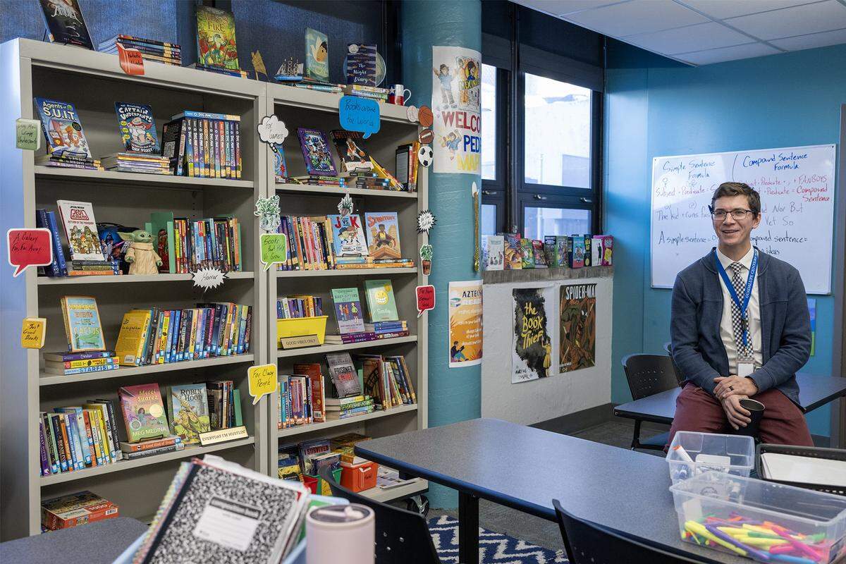In his classroom, Christopher Leavens, an English language development teacher at Guadalupe Centers Middle School, talks about the benefits students get from reading books, on Thursday, Dec. 4, 2025, in Kansas City. The school does not have a library, so Leavens, has started a small library in his classroom for the students to have access to more books.