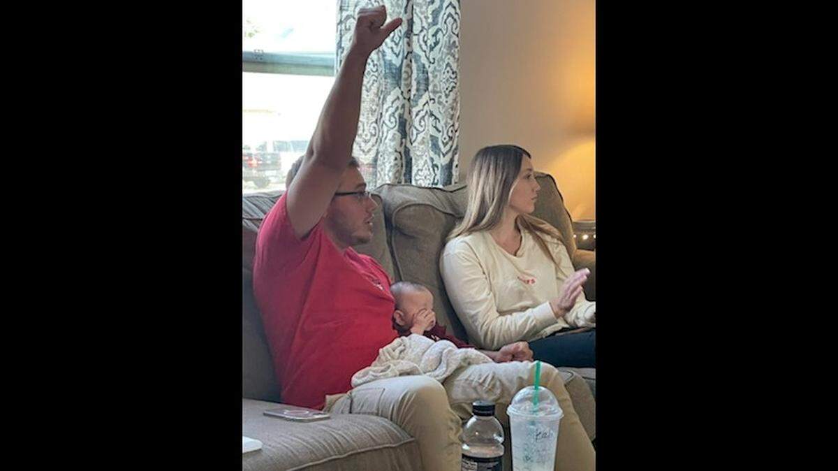 Riley Youngblood, 23, watching the Kansas City Chiefs play the Philadelphia Eagles on Oct. 3, 2021, with his partner, Kali, and daughter, Kendall.