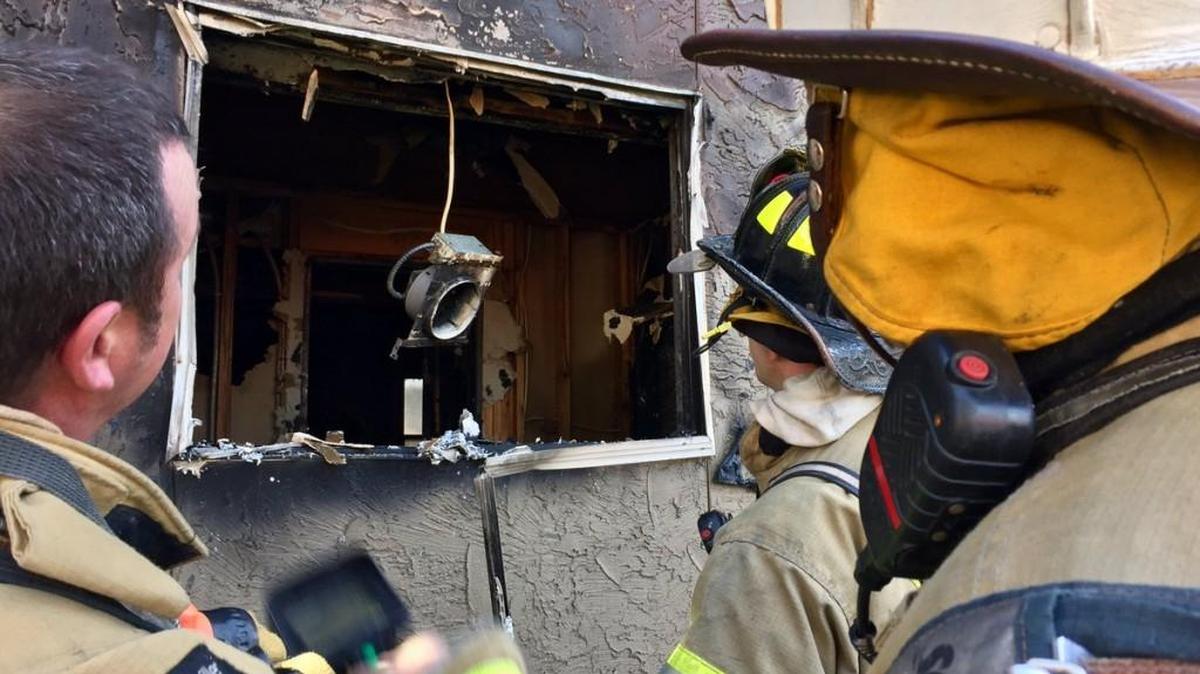 Firefighters survey damage after a fire Saturday at an Overland Park apartment complex.