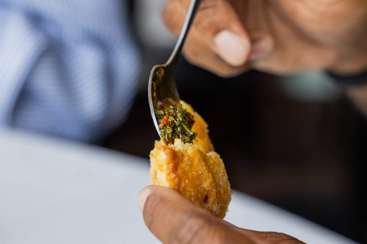 Chimichurri sauce made from a family recipe is spooned into an empanada at Piropos on Tuesday, June 2, 2026.