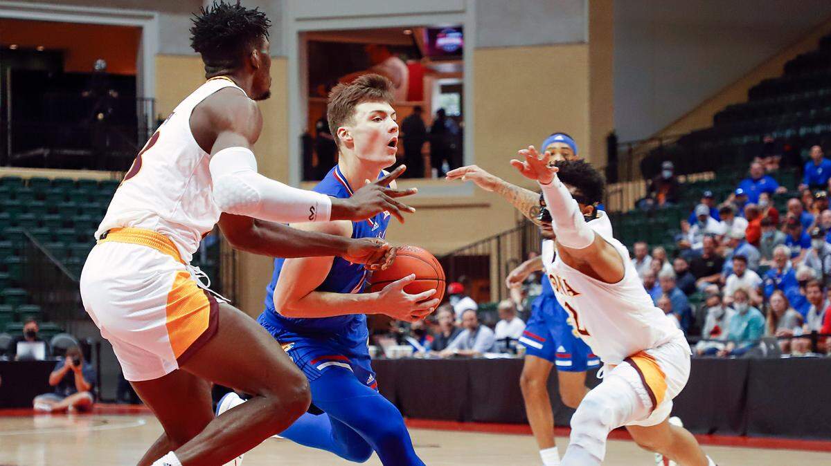 Kansas guard Christian Braun drives between Iona forward Nelly Junior Joseph (left) and guard Elijah Joiner during the Jayhawks’ win Sunday in the ESPN Events Invitational third-place game.