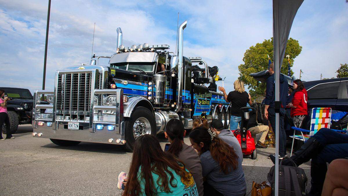 A tow truck passes by the Langfords during a parade honoring Tucker, a 3-year-old who is battling terminal illness.
