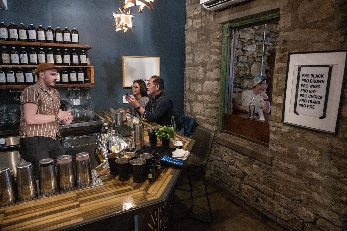 Nate Tallman, left, bar manager at Drastic Measures in downtown Shawnee, talks with customers on Thursday, March 12, 2026. The bar is again up for a James Beard Award in the Outstanding Bar category.
