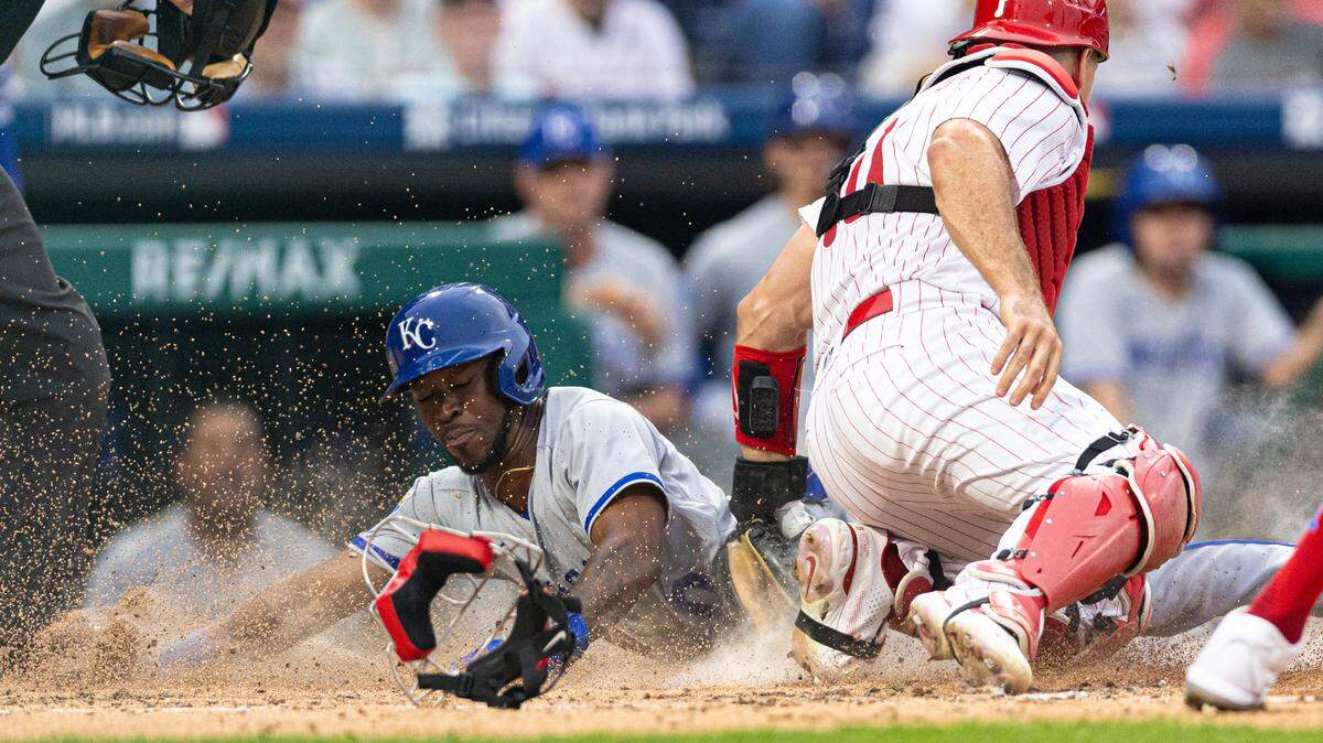 Kansas City Royals second baseman Samad Taylor (0) slides past the tag attempt of Philadelphia Phillies catcher J.T. Realmuto (10) on a squeeze play during the fifth inning at Citizens Bank Park on Aug. 5, 2023.