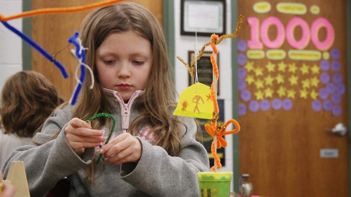 Alexis Driskell, 7, twists another pipe cleaner as she prepares to add it to her Calder-inspired mobile during a program at the Colbern Road branch of the Mid-Continent Public Library.