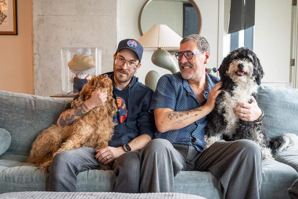 Kris Saim and his husband, Anthony, with their dogs in their home on Friday, April 10, in Kansas City. Saim has Stage 4 terminal cancer and is recording a podcast, Dying Out Loud, that talks about death. Saim's husband helped spur the idea of recording about the subject, and is also a producer on the podcast.