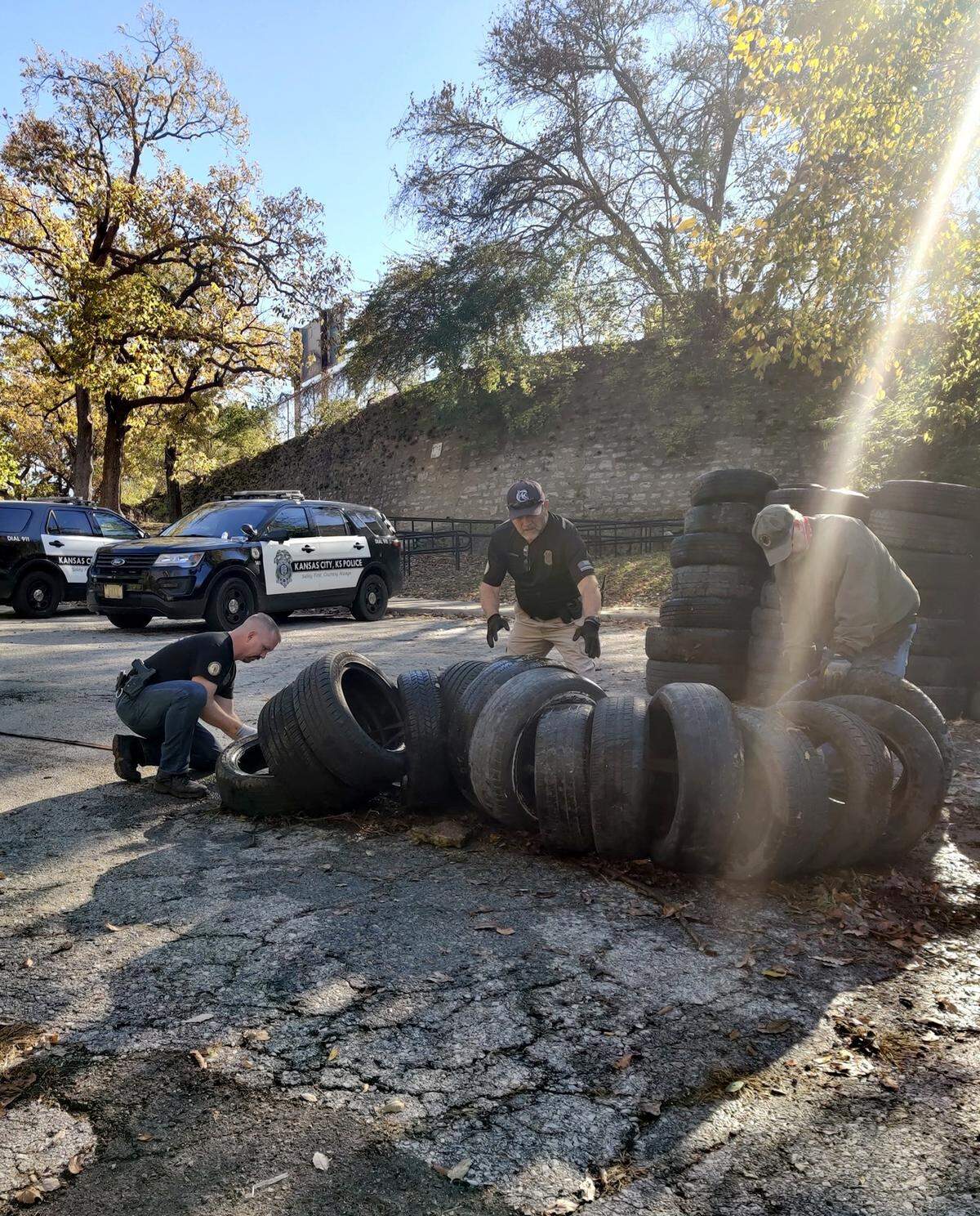 KCK police officers assist with a discarded tire cleanup at the arch.